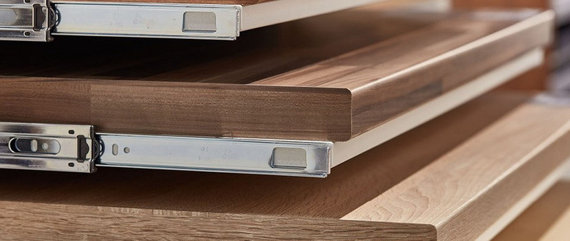 Gestapelte Holzarbeitsplatten mit Metallschienen, ideal für Küchen- und Möbelbau.