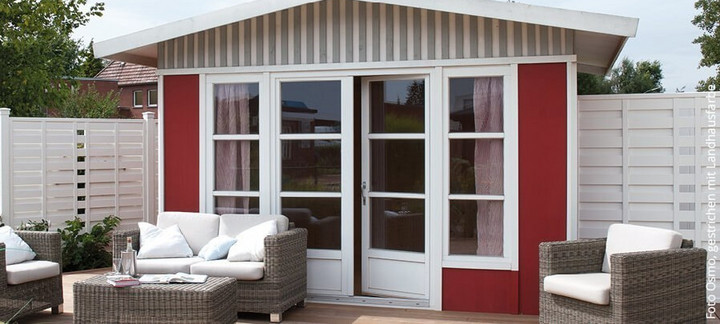 Gartenhaus mit angrenzender Terrasse, ausgestattet mit Gartenmöbeln, umgeben von einem grünen Garten.