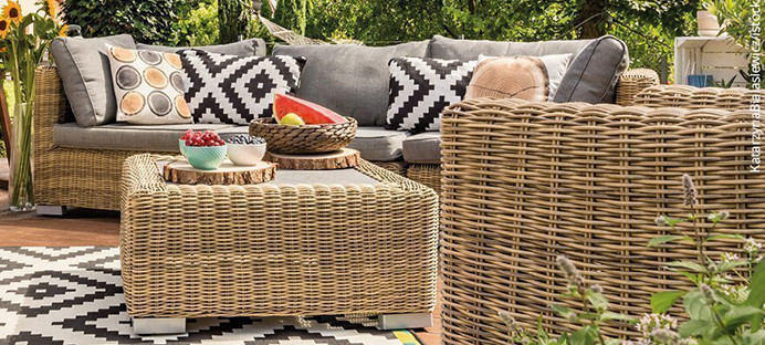 Gemütliche Gartenmöbel mit bunten Kissen auf einer Terrasse