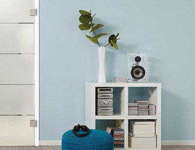 Glastür aus satiniertem Glas mit vier quer verlaufenden Streifen. Die Tür steht vor einer blauen Wand. Links und rechts sind dekorative Elemente sichtbar.