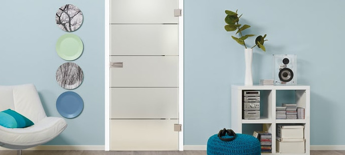 Glastür aus satiniertem Glas mit vier quer verlaufenden Streifen. Die Tür steht vor einer blauen Wand. Links und rechts sind dekorative Elemente sichtbar.