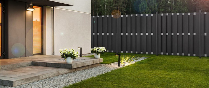 Grauer WPC-Zaun in der Nähe eines Hauses