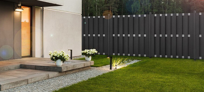 Grauer WPC-Zaun in der Nähe eines Hauses