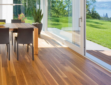 Die Küche ist mit massivem Boden ausgelegt. In der Mitte steht ein massiver Tisch mit Stühlen, und durch die Glasfenster sieht man den Ausgang zur Terrasse und zum Garten.