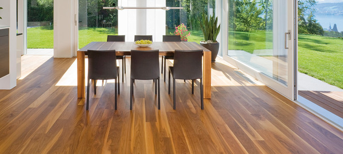 Die Küche ist mit massivem Boden ausgelegt. In der Mitte steht ein massiver Tisch mit Stühlen, und durch die Glasfenster sieht man den Ausgang zur Terrasse und zum Garten.