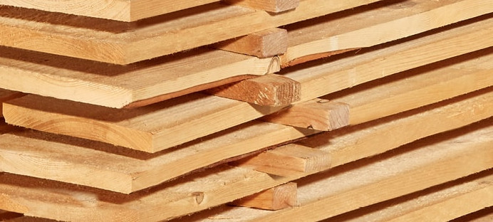 Gestapelte Schalbretter aus Holz mit sägerauer Oberfläche, ideal für den Bau- und Konstruktionsbereich.